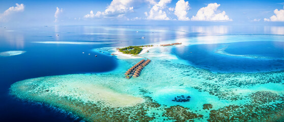 Wall Mural - Panoramic aerial view of a turquoise coral reef and lagoon with a tropical paradise island and calm sea at the Maldives, Indian Ocean