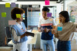 © Wavebreak Media - Busy diverse creative colleagues using tablet, brainstorming and making notes on glass wall