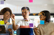 © Wavebreak Media - Happy diverse creative colleagues using tablet, brainstorming and making notes on glass wall