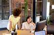 © Wavebreak Media - Two happy diverse female creative colleagues looking at computer and discussing at desk in office