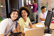 © Wavebreak Media - Portrait of two happy diverse female creative colleagues smiling at desk in busy casual office