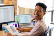 © Wavebreak Media - Portrait of smiling asian male designer working at desk in creative office