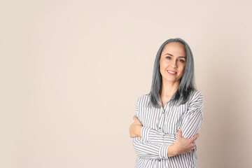 Poster - Portrait of smiling woman with ash hair color on beige background. Space for text