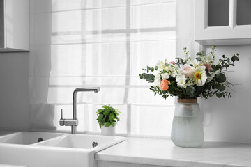 Canvas Print - Bouquet of beautiful flowers on white countertop in kitchen