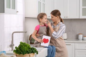 Canvas Print - Little daughter congratulating mom with greeting card in kitchen. Happy Mother's Day