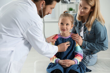 Canvas Print - Mother and daughter having appointment with doctor. Pediatrician examining patient with stethoscope in clinic