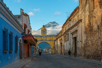 Wall Mural - Antigua city and Santa Catalina arch with unrecognizable people before sunrise, Guatemala.