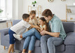 © Studio Romantic - Cheerful parents playing with daughter and son at home. Funny Caucasian woman, man and their son and daughter having fun tickling each other together. Family, leisure and people concept.