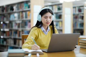 Poster - Student studying at library with laptop.