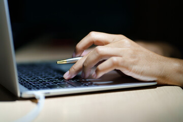 Wall Mural - Close up of a man's hands on keyboard of lap top in the dark room, people working at home, modern white notebook. Internet, work, technology concept.