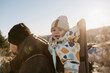 © Johnér - Smiling toddler in baby carrier looking at camera