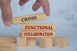 Hand placing wooden blocks with cross functional collaboration text on wooden blocks. Operational excellence and business concept