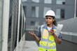 © amorn - Female engineer worker working, holding blueprint and inspecting structure of building at rooftop of building at construction site