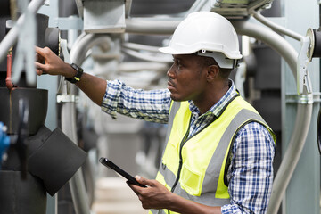 Wall Mural - Male plumber engineer inspecting quality of work at sewer pipes area at construction site. African American male engineer worker check or maintenance sewer pipe network system at rooftop of building