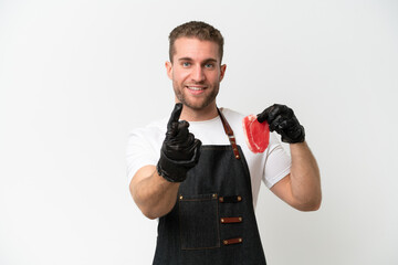 Poster - Butcher caucasian man wearing an apron and serving fresh cut meat isolated on white background doing coming gesture