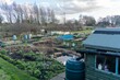 Allotment in the month of March, with shed, rain water barrel and compost bins. Preparing for Spring