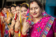  Election in india. Group of happy traditional indian women standing in queue showing their finger marked with black ink after casting vote. 