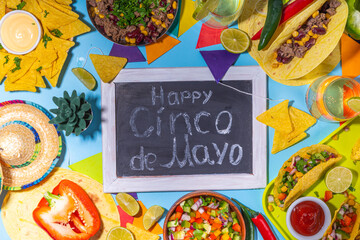 Wall Mural - Cinco de mayo party food. Mexican holiday Cinco de mayo traditional dishes, snacks, tortilla corn chips, nachos, tacos, salsa, sauces. Friends and family feast background top view copy space