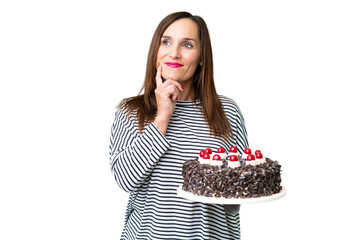 Wall Mural - Middle age caucasian woman holding birthday cake over isolated chroma key background thinking an idea while looking up
