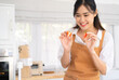 © Fahng - Social media influencer. Food blogger creating content. Female chef holding strawberry , shooting video using camera on tripod.  baker online courses,live stream . Food vlogger in kitchen.