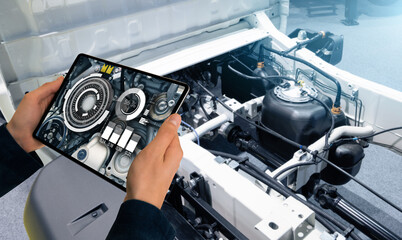 Serviceman with digital tablet on the background of the truck in the car service	