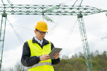 Poster - Engineer with digital tablet on a background of power line tower