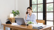 © Puwasit Inyavileart - Woman working at home, Attractive woman chatting or talking with colleague on mobile phone at her home, Work for home, Remote conversation or meeting , Stay home, Use a cell phone or smartphone.