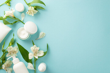 Natural skincare concept. Top view flat lay of mock up cream bottles, jars, serum, pipette with white flower on pastel blue background with empty space for text or advert. Modern and creative