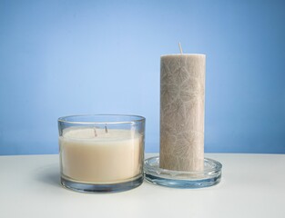 Wall Mural - Closeup of two candles on a white surface with space for text