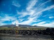 © Jimmy Lee Wolff/Wirestock Creators - Small speed limit sign with the number 60 printed on it with a green field on a mountain range