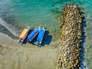 Sticker - Aerial view of three boats docked at a tranquil shoreline, with blue-green waters