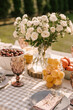rustic birthday decor on the street, table setting with fruits, beautiful dishes and flowers