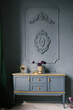 Vintage chest of drawers decorated with flowers in the interior with stucco on the wall, luxury home design