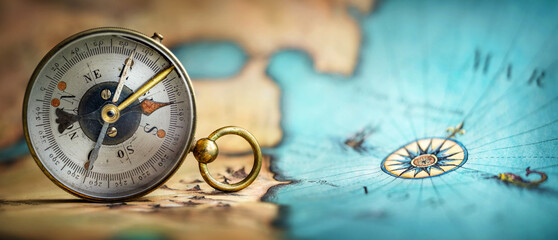 Poster - Magnetic old compass on world map. Travel, geography, navigation, tourism and exploration concept background. Macro photo. Very shallow focus.
