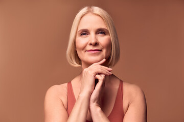 Wall Mural - Skin care and women's health. beautiful retired woman posing on a beige background.