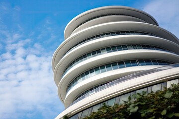 Wall Mural - towering building with a circular window at its peak, against a blue sky background. Generative AI