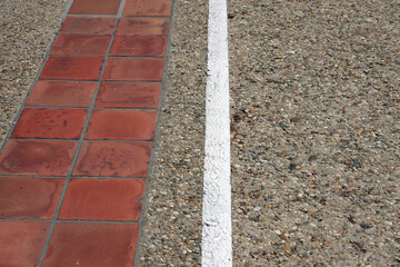 Wall Mural - Concrete sidewalk with red tiles and a painted white border line