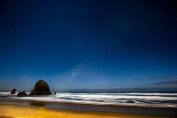 Wall Mural - USA, Oregon. Cannon Beach and Haystack Rock stars showing during blue light.