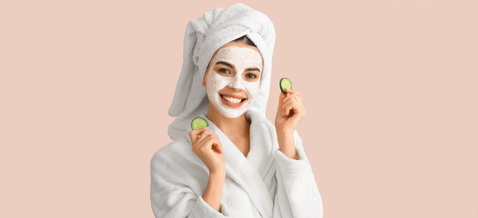 Poster - Beautiful young woman with cucumber slices and facial mask on beige background