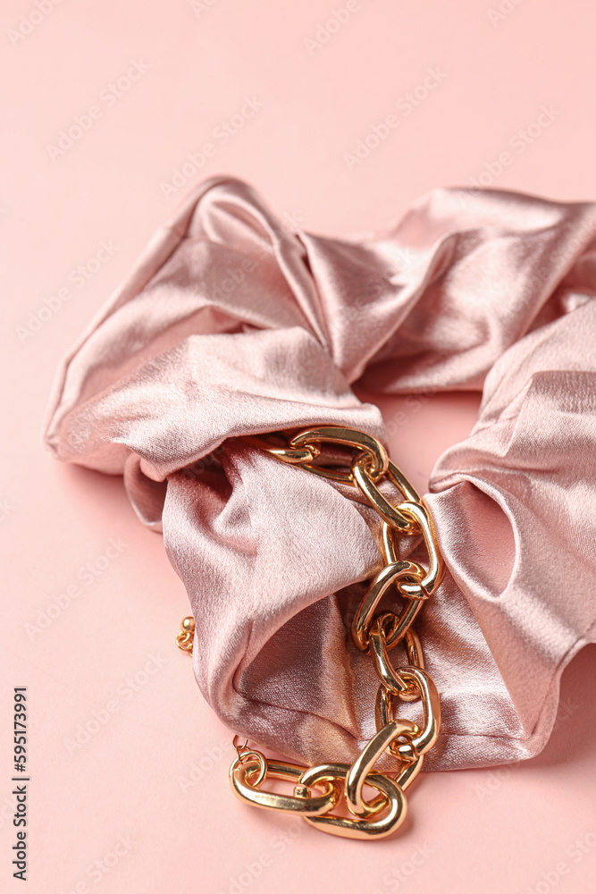 Silk scrunchy and bracelet on pink background, closeup