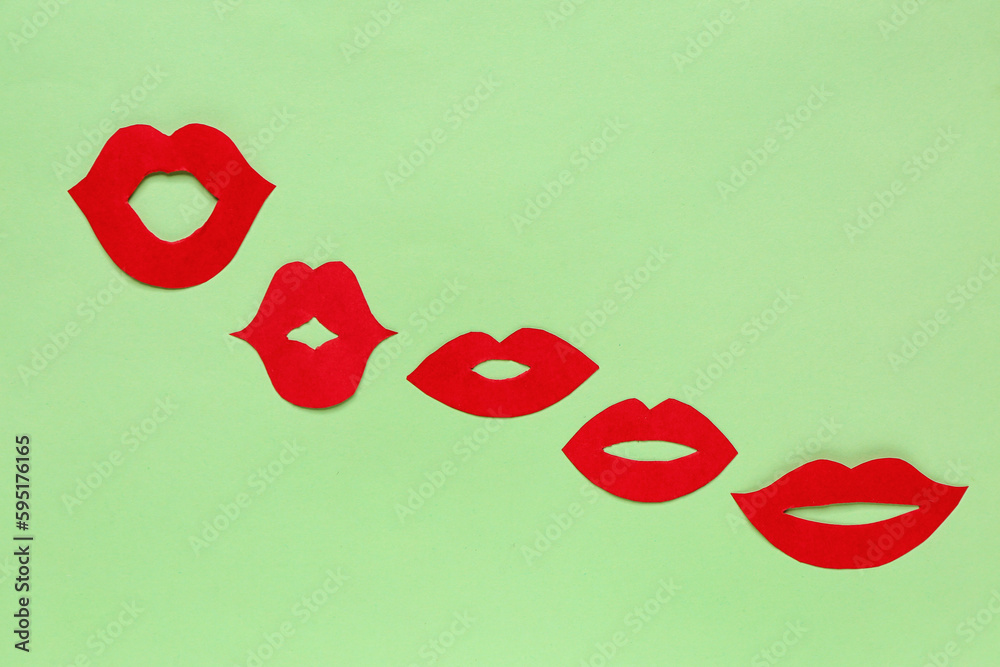 Red paper lips on green background