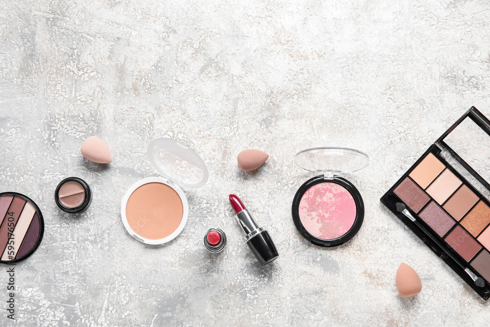 Decorative cosmetics with sponges on grunge background