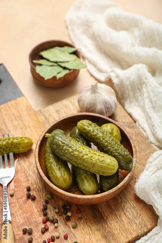 Bowl with tasty fermented cucumbers on beige background