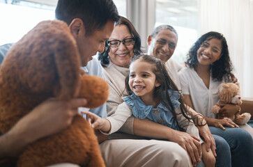 Big family, parents and girl with teddy bear on couch, grandparent and smile for game in home living room. Men, women and female child with toys, love and happiness on lounge sofa in house on holiday