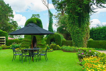 Table, chairs and umbrella set in the garden, in the relax area