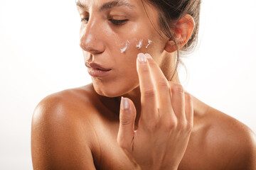 Wall Mural - Close up of a girl putting face cream on