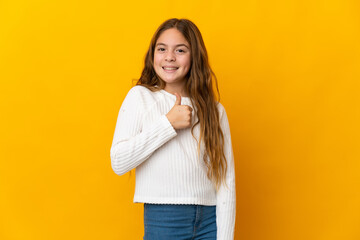 Sticker - Child over isolated yellow background giving a thumbs up gesture