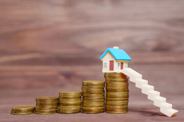 Miniature Staircase to a Tiny Toy House on Top of Coins Stack