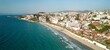 Aerial view of a beach located in Kusadasi with a large pier extending into the ocean