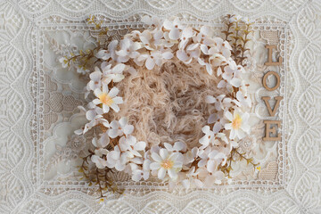 Newborn digital backdrop with wreath of handmade flowers and word love on boho background. Newborn background. top view.